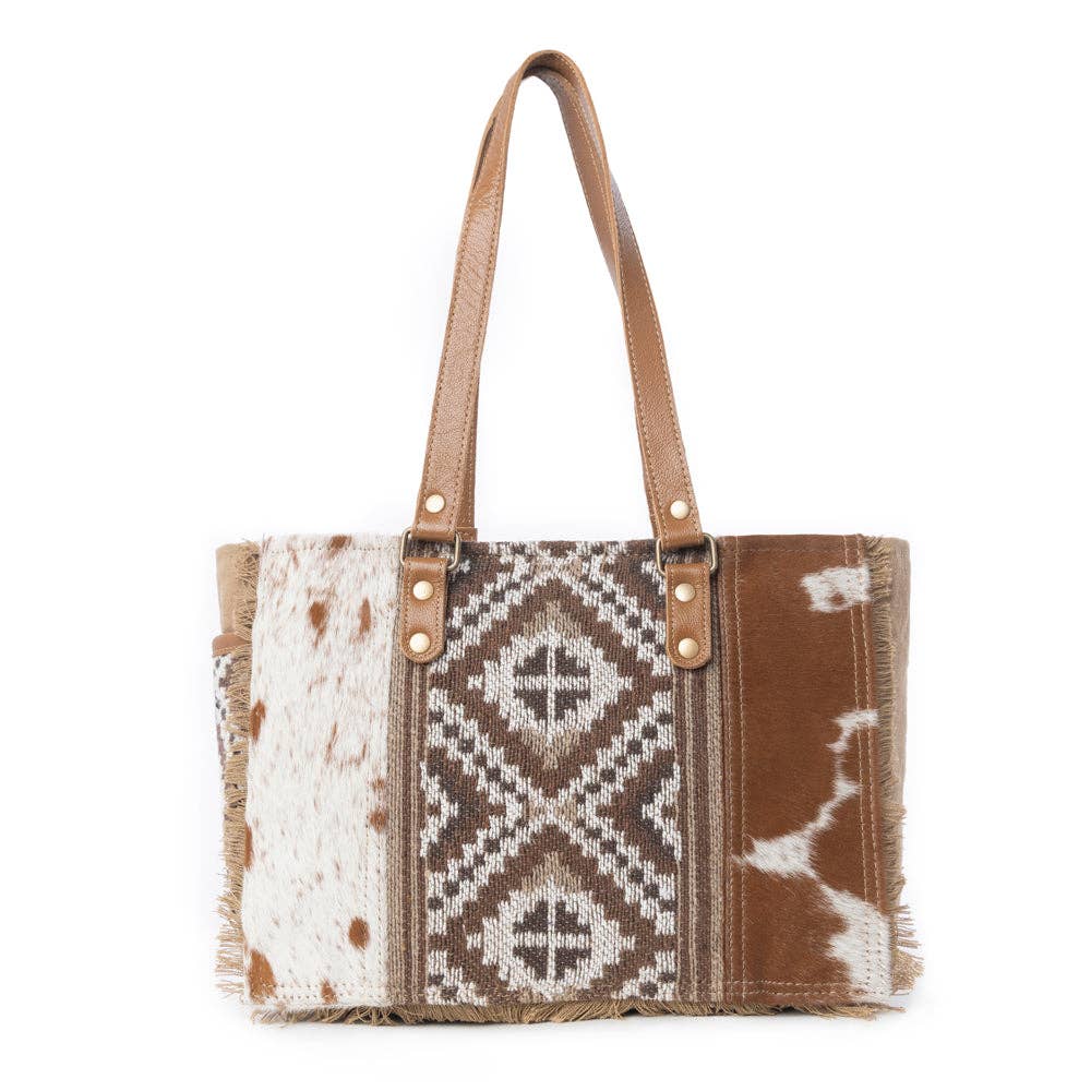 Stylish crossbody bag with a mix of light and dark patterns, featuring a textured surface and two handles. Perfect for nights out.