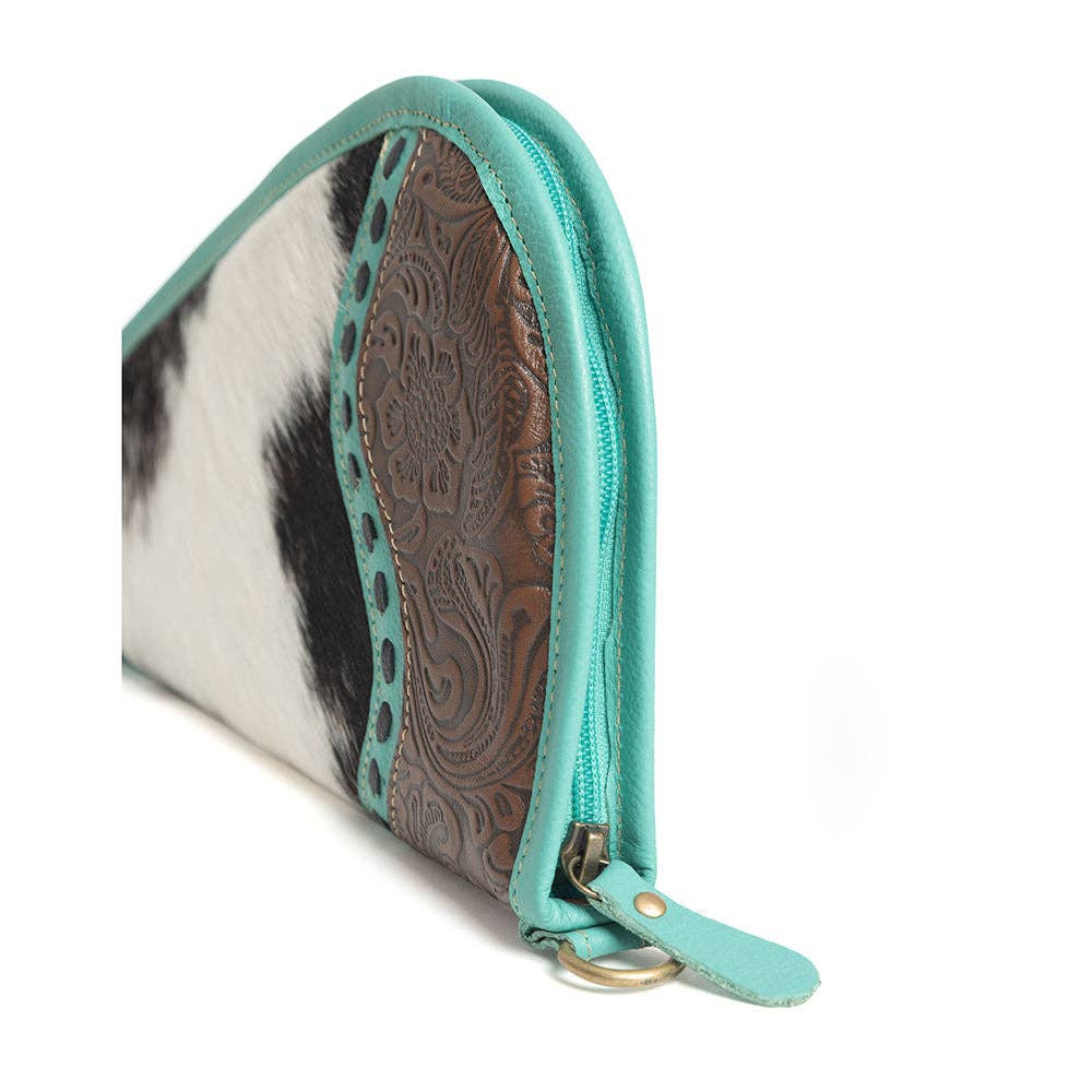 Turquoise-trimmed leather gun case featuring a hand-tooled panel and black-and-white hairon exterior with a wrap-around zipper.