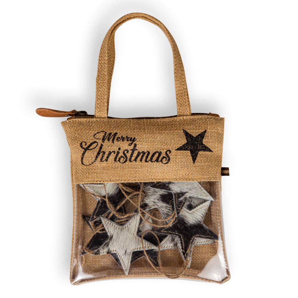 Woven burlap bag with a 'Merry Christmas' design holding ten black hair-on hide star ornaments with stitched edges.