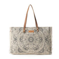 Ivory weekender bag featuring a vintage mandala print, leather handle accents, and fringe edges, perfect for travel.