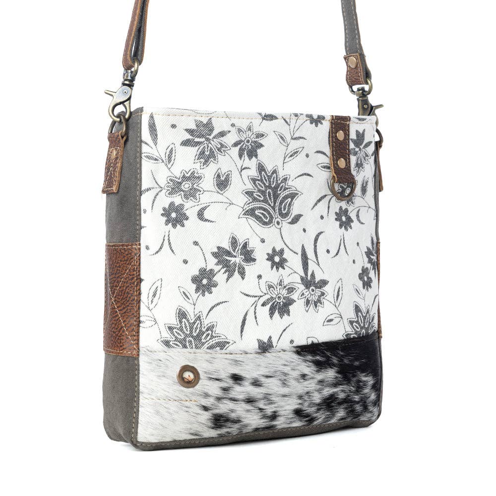 Floral design shoulder bag featuring a hairon panel, zippered top closure, and a stylish shoulder strap.
