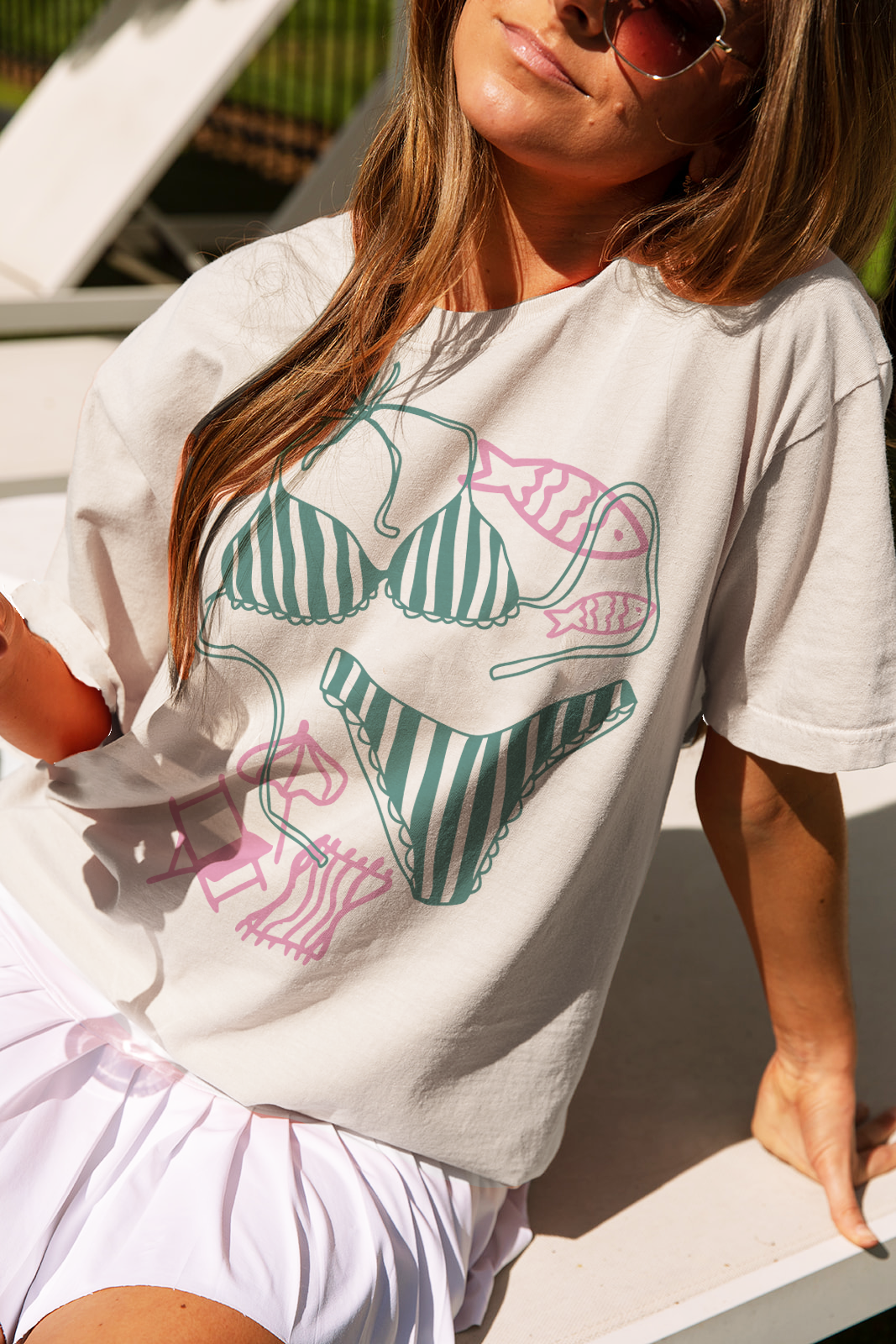 A playful ivory tee featuring a fun graphic design of bikinis, perfect for summer outings and beach days.