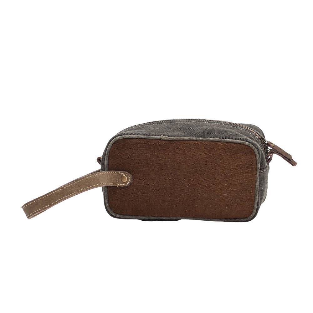 Dopp kit featuring a wide mouth opening, secure zippered closure, and a convenient handle, made with a mix of canvas and leather.