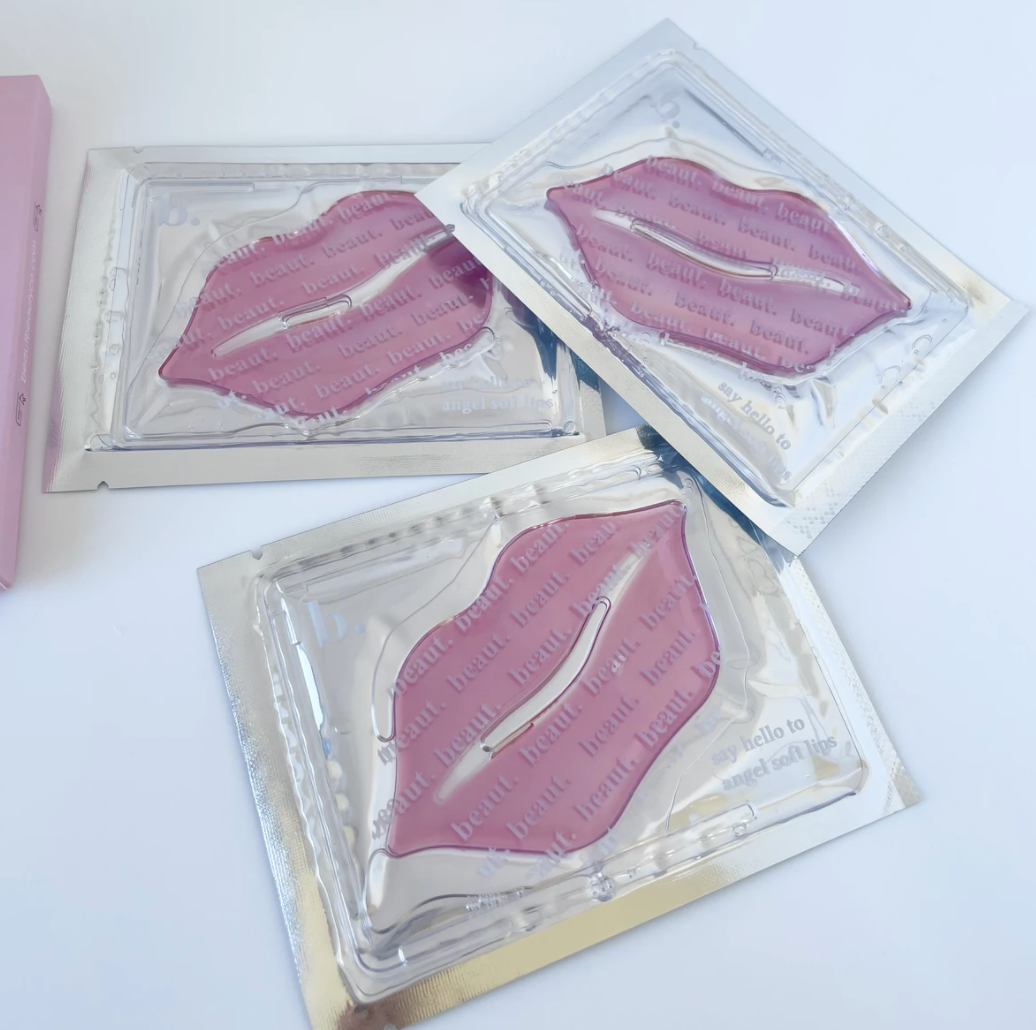 Three pinkish lip masks in glossy foil pouches, designed for intense hydration and lip care.