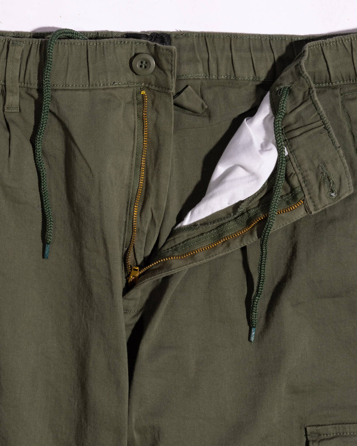 Relaxed-fit cotton cargo pants featuring an elastic drawstring waistband, zip fly, and multiple pockets for practicality.
