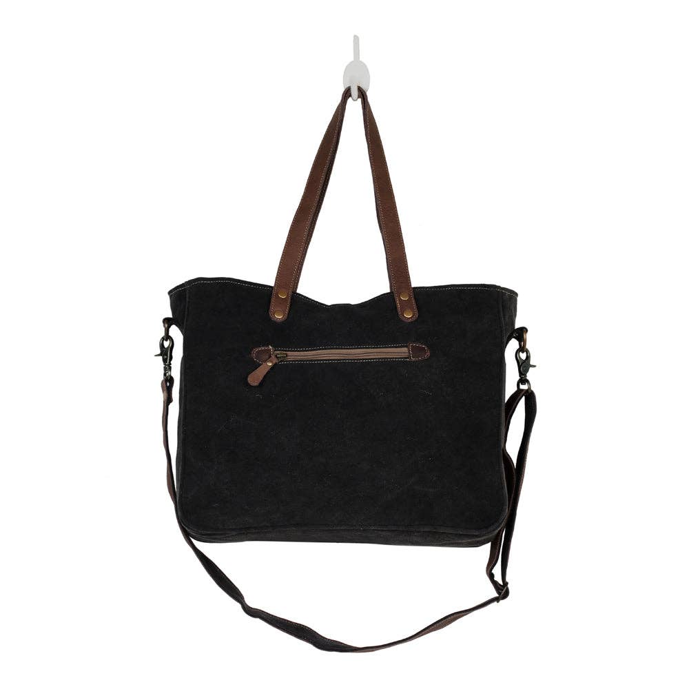 Mid-sized black messenger bag with brown straps, featuring a zippered back pocket and multiple pockets for organization.