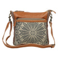 Small crossbody bag in brown canvas and leather with a decorative front pocket, perfect for carrying essentials.