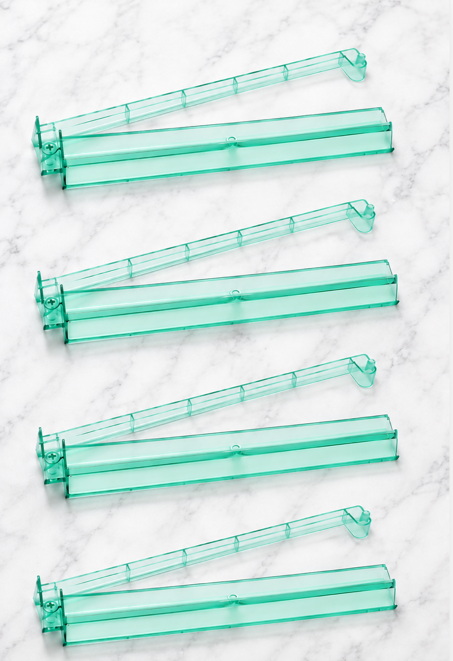 Set of four green acrylic Mahjong tile racks with pushers, featuring a heart-shaped design for organized gameplay.