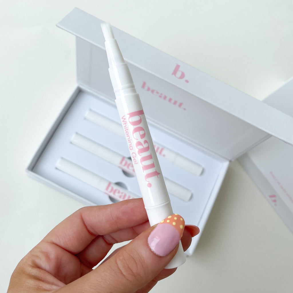 Three smile pens arranged in a white and pink box, designed for teeth whitening treatments.