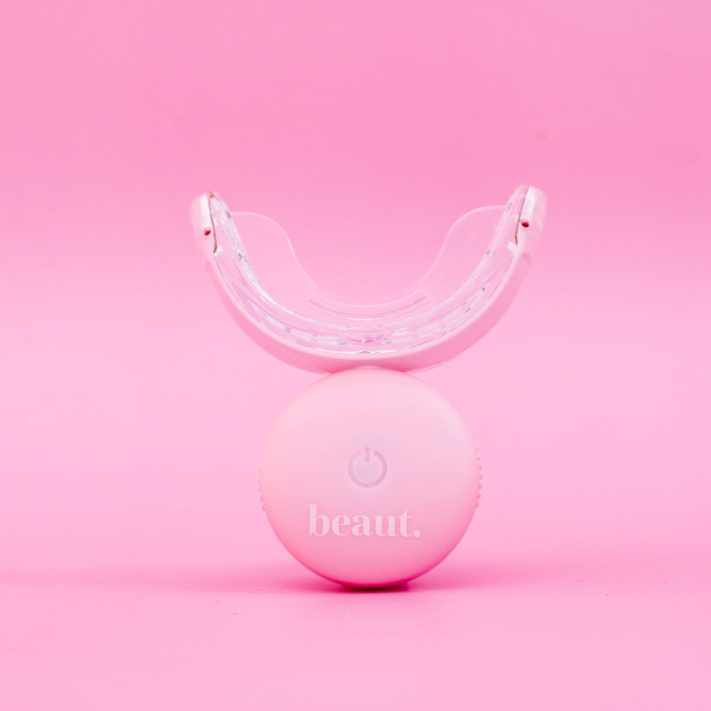 Polly Pink Kit, a waterproof and wireless oral care device with a rounded base and mouthpiece for effective treatment.