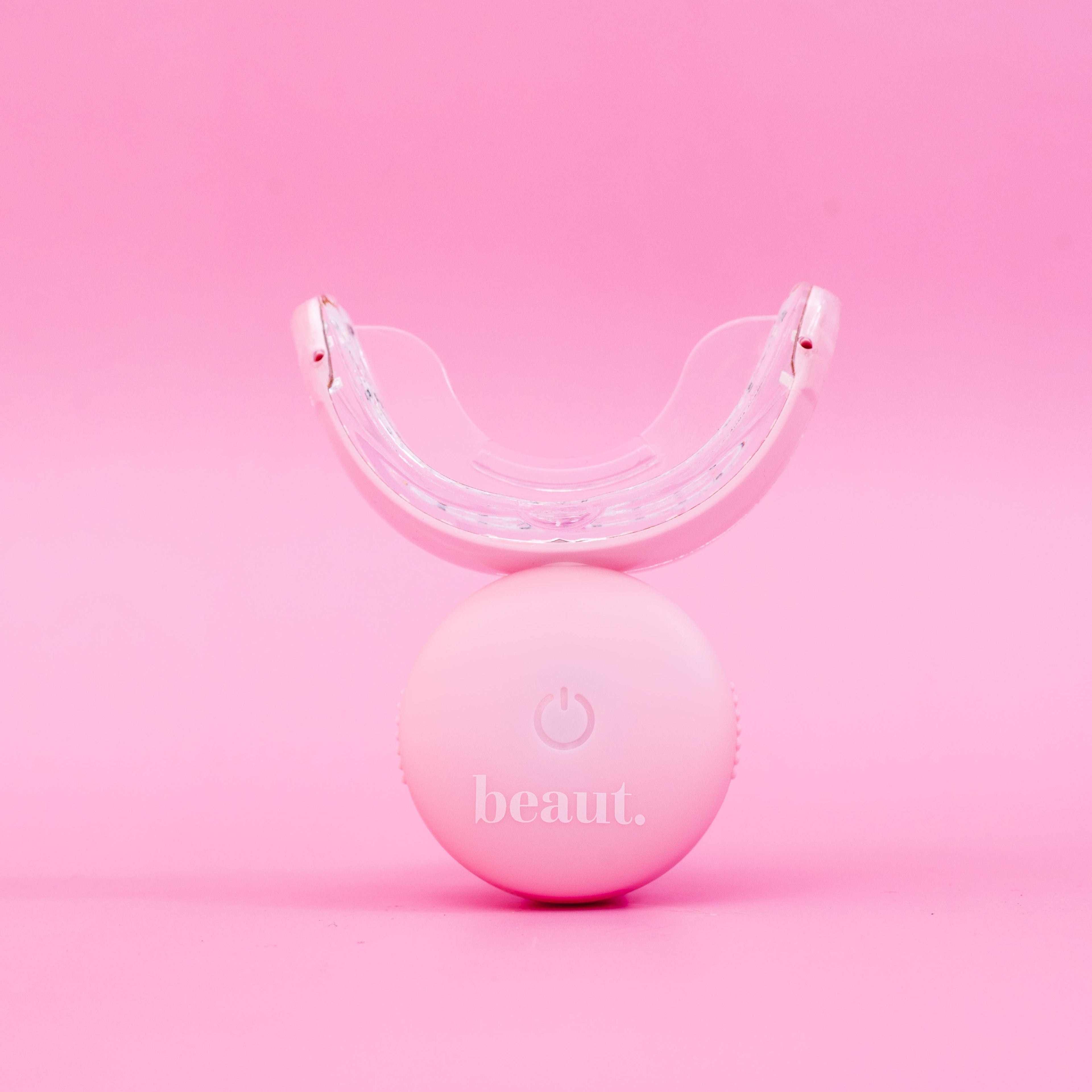 Polly Pink Kit, a waterproof and wireless oral care device with a rounded base and mouthpiece for effective treatment.