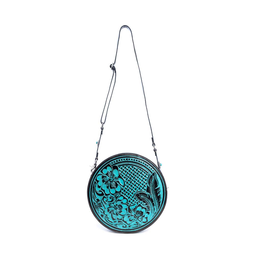 Round handbag featuring a turquoise front with floral designs, detachable shoulder strap, and zippered closure.