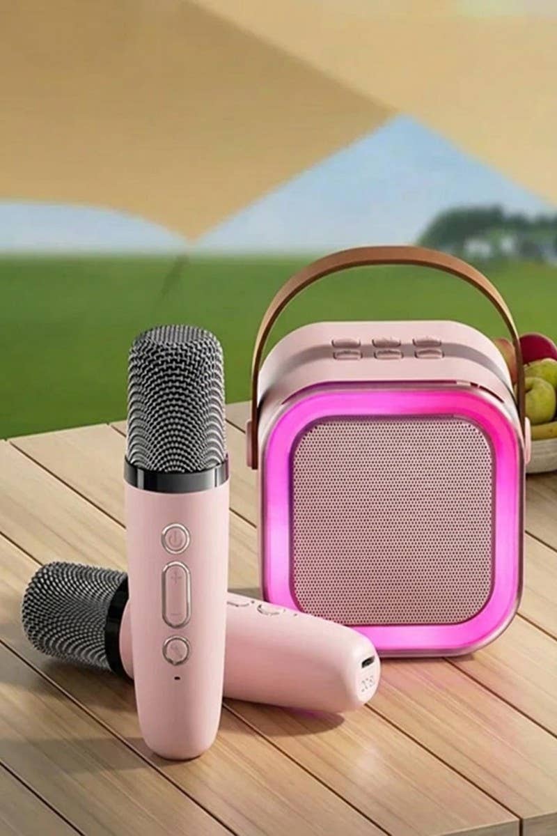 Pink karaoke Bluetooth speaker with LED lighting and two microphones, designed for easy carrying and fun sing-alongs.
