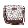 A stylish shoulder bag featuring a mix of light and dark patterned fabric with leather accents, perfect for everyday use.