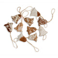 A collection of ten unique brown and white hair-on hide bell ornaments with natural jute hangers.