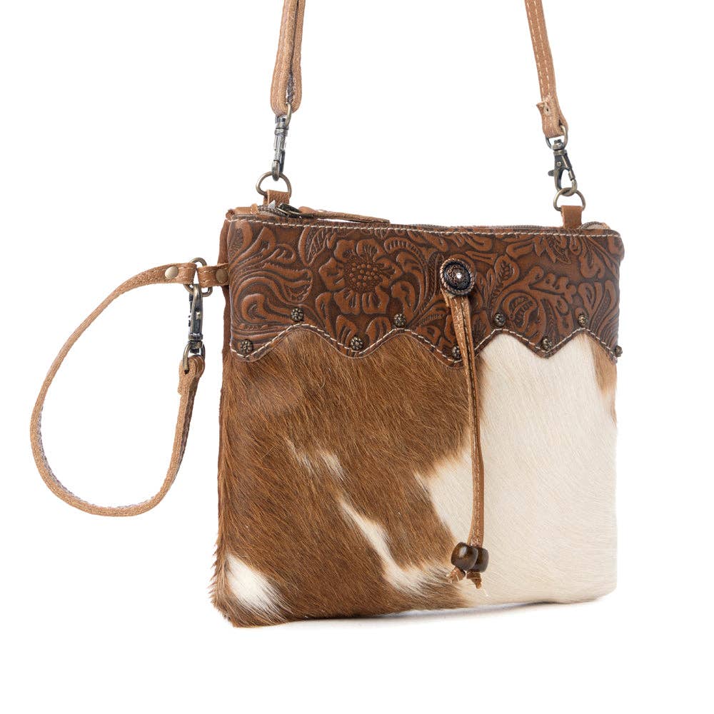 Ornate brown leather and hairon handbag featuring adjustable leather straps and a strong back zipper for secure storage.