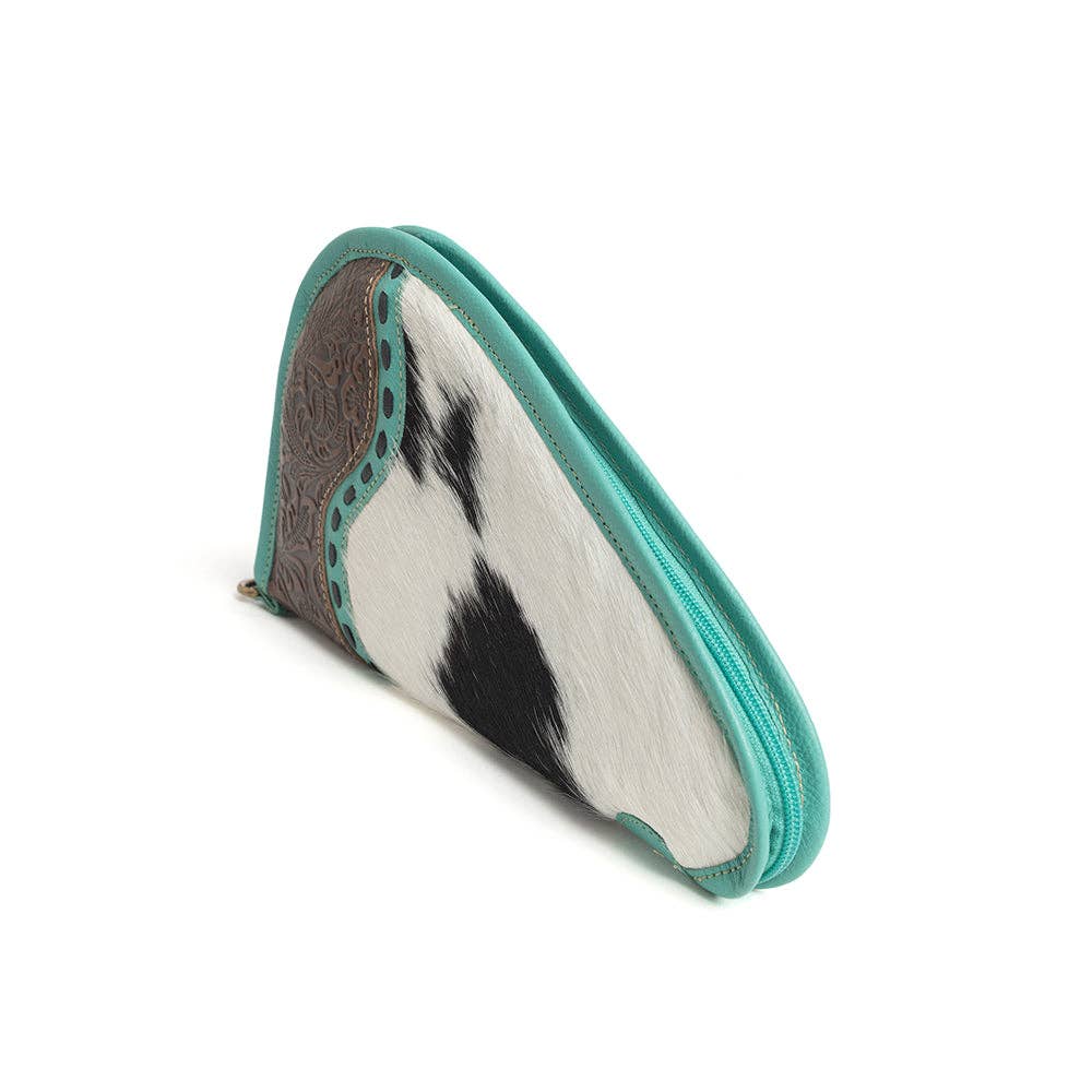 Turquoise-trimmed leather gun case featuring a hand-tooled panel and black-and-white hairon design with a wrap-around zipper.