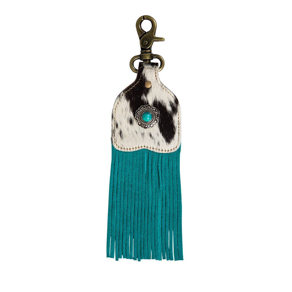 Fringed key fob featuring hair-on hide, a medallion, and turquoise fringe, perfect for adding personality to your keys.