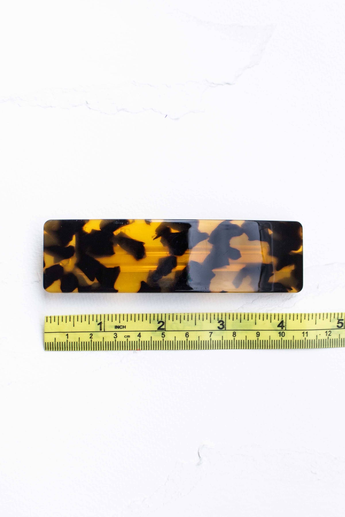 Rectangular hair barrette in a marbled tortoiseshell pattern, showcasing a smooth, glossy finish and sturdy design.