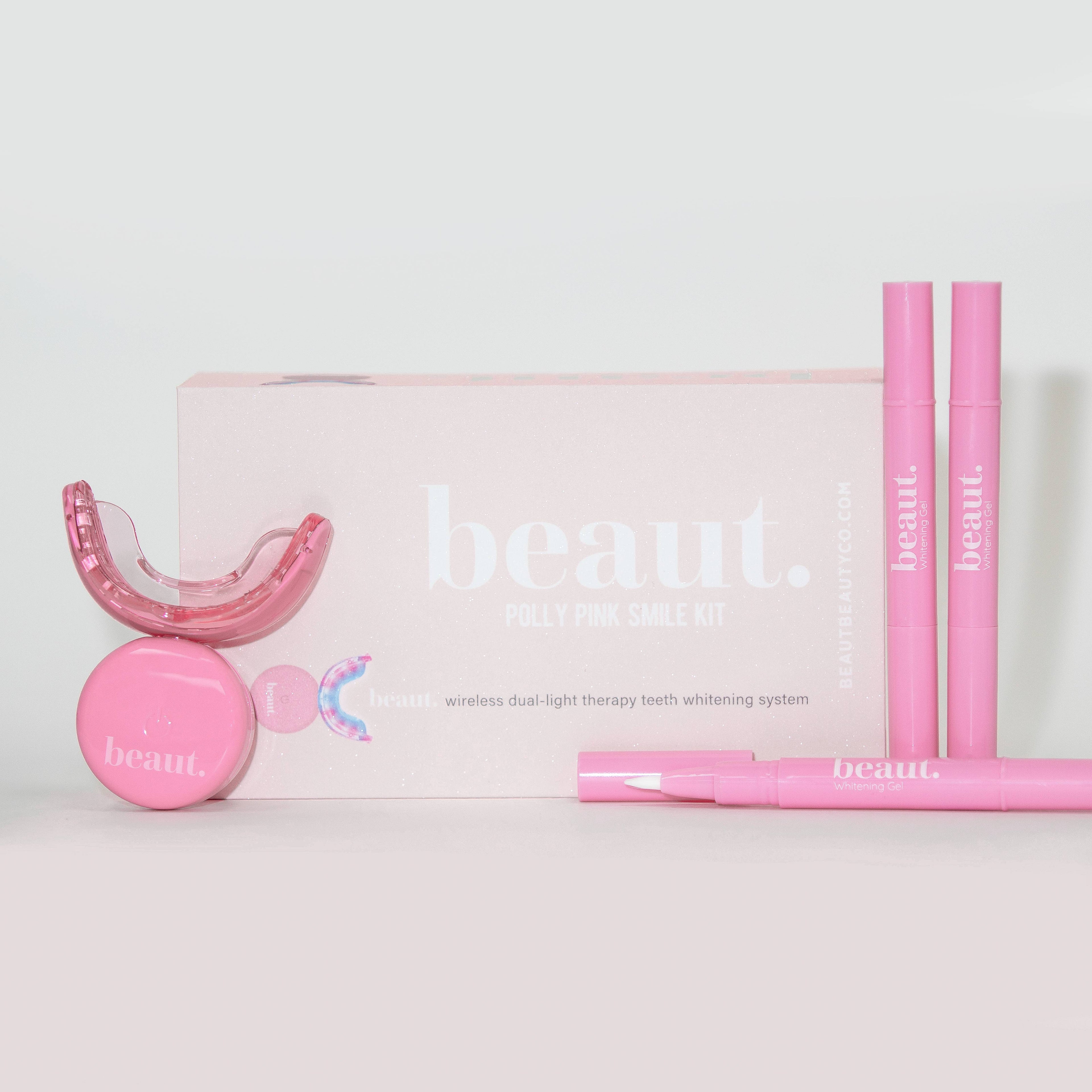Polly Pink Kit featuring a mouthpiece, two pink smile pens, and a circular device for oral care and whitening.