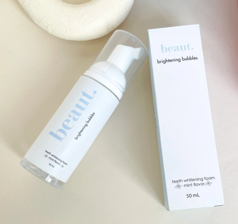 Brightening Bubbles teeth whitening foam in a pump bottle, featuring a mint flavor and labeled for daily use.