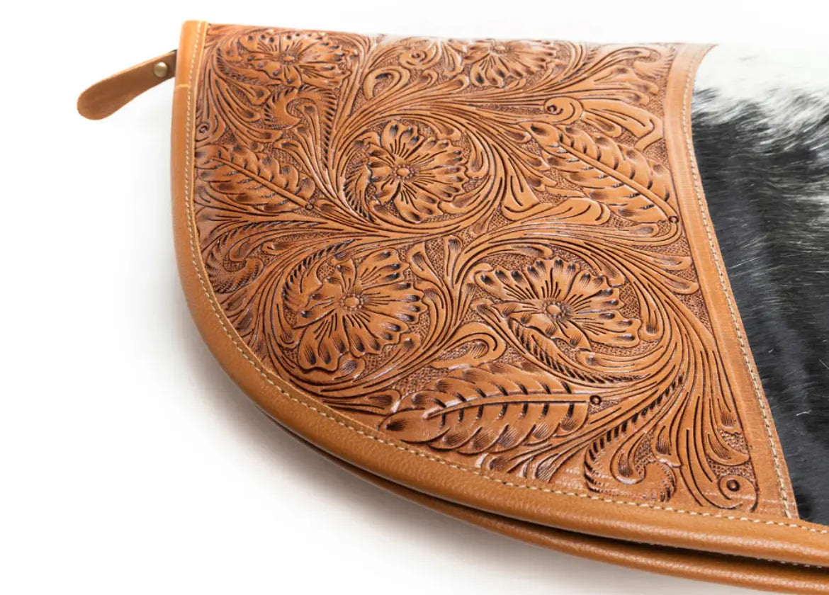 Black and white hair-on hide rifle case with hand-tooled leather panel and caramel brown leather trim.