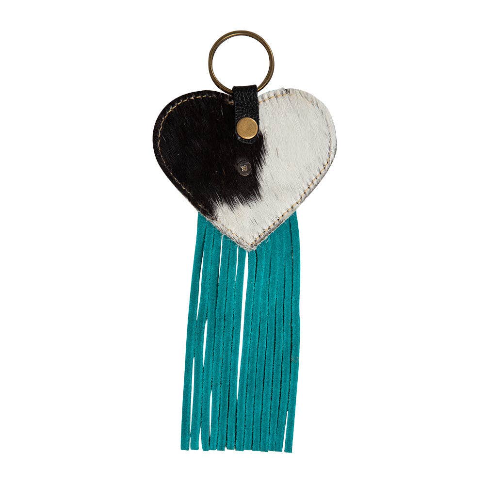 Heart-shaped key fob featuring a hair-on hide design with turquoise fringe and a metal ring for attachment.