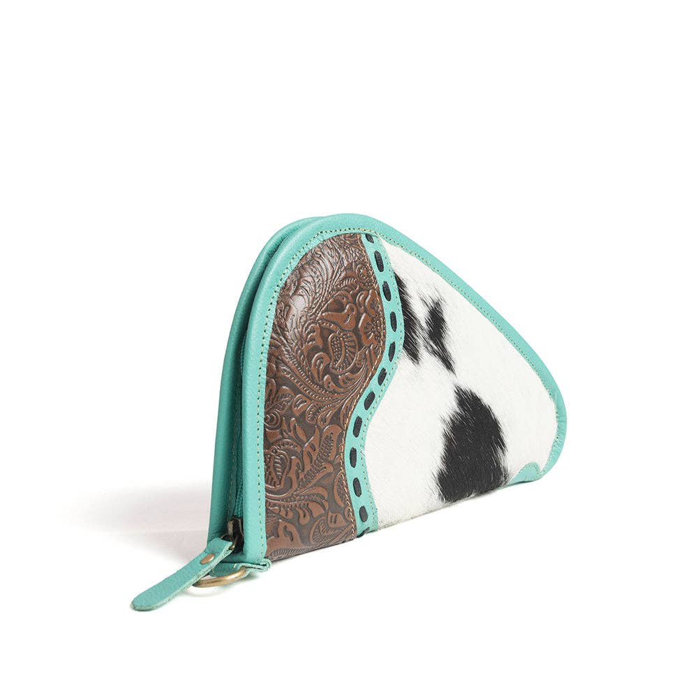 Turquoise-trimmed leather gun case featuring a hand-tooled panel and black-and-white hairon design with a wrap-around zipper.