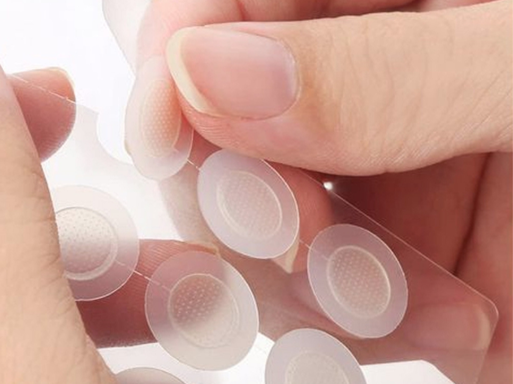 Nine circular microneedle patches with a textured surface designed for fast healing of pimples.