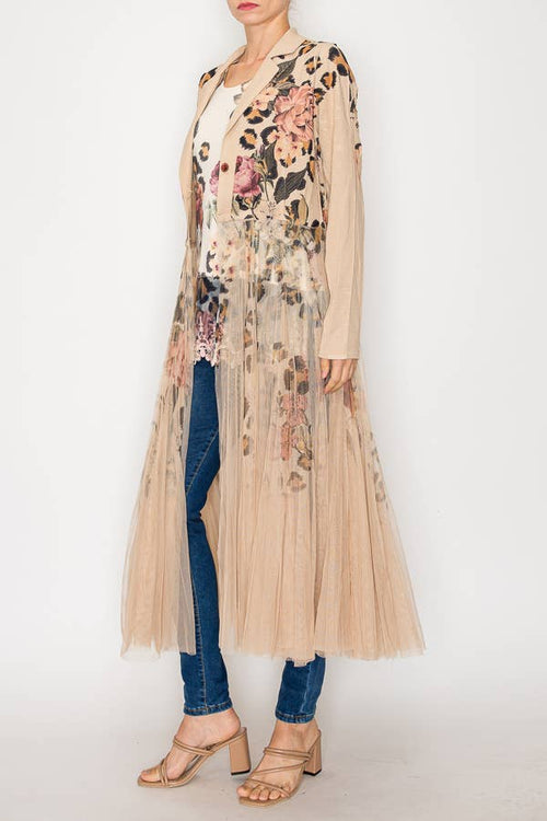 Longline blazer jacket with a floral design and mesh tulle panel, styled over a lighter top with fitted jeans and heels.