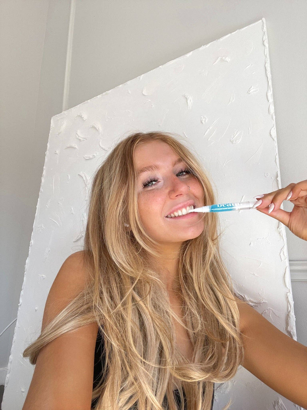 A person holding the Bye Bye Sensitivity Gel Pen, designed to help reduce teeth sensitivity with Vitamin E oil treatment.