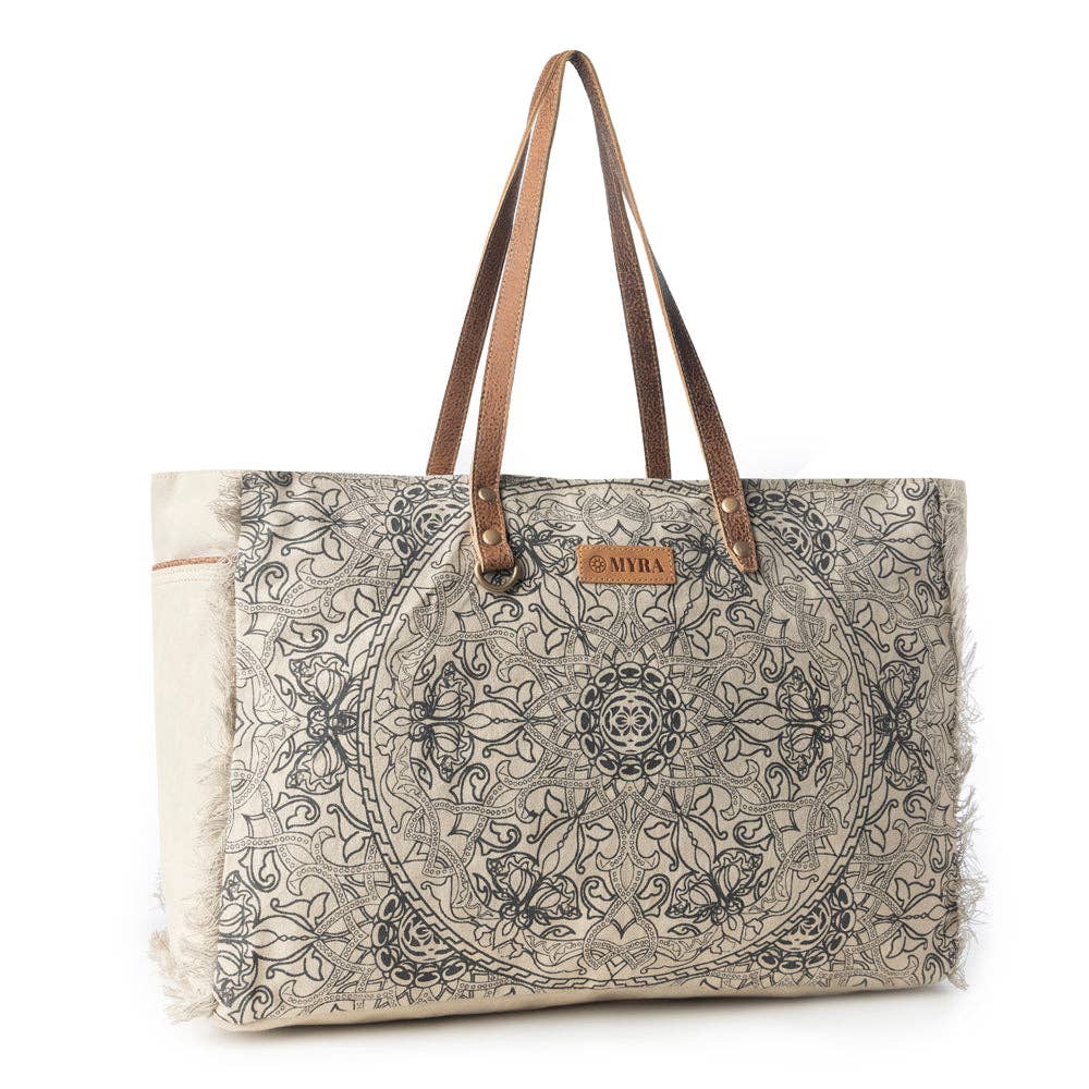 Vintage mandala print weekender bag in ivory with leather handle accents and fringe edges, featuring spacious compartments for travel.