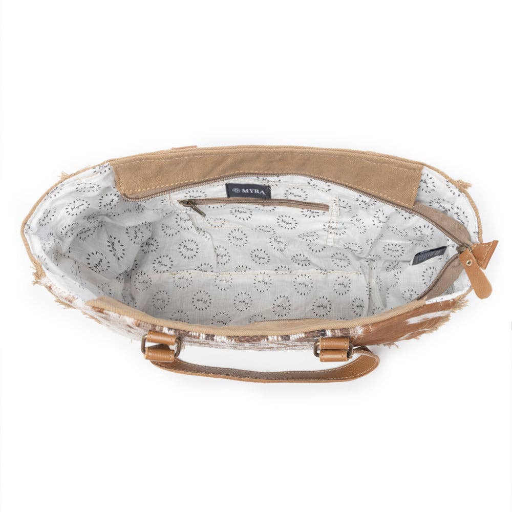 Structured small crossbody bag with a light-colored circular patterned lining and a single handle, perfect for stylish outings.