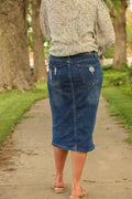Denim skirt featuring a fitted silhouette with front and back pockets and distressed patches on the front.