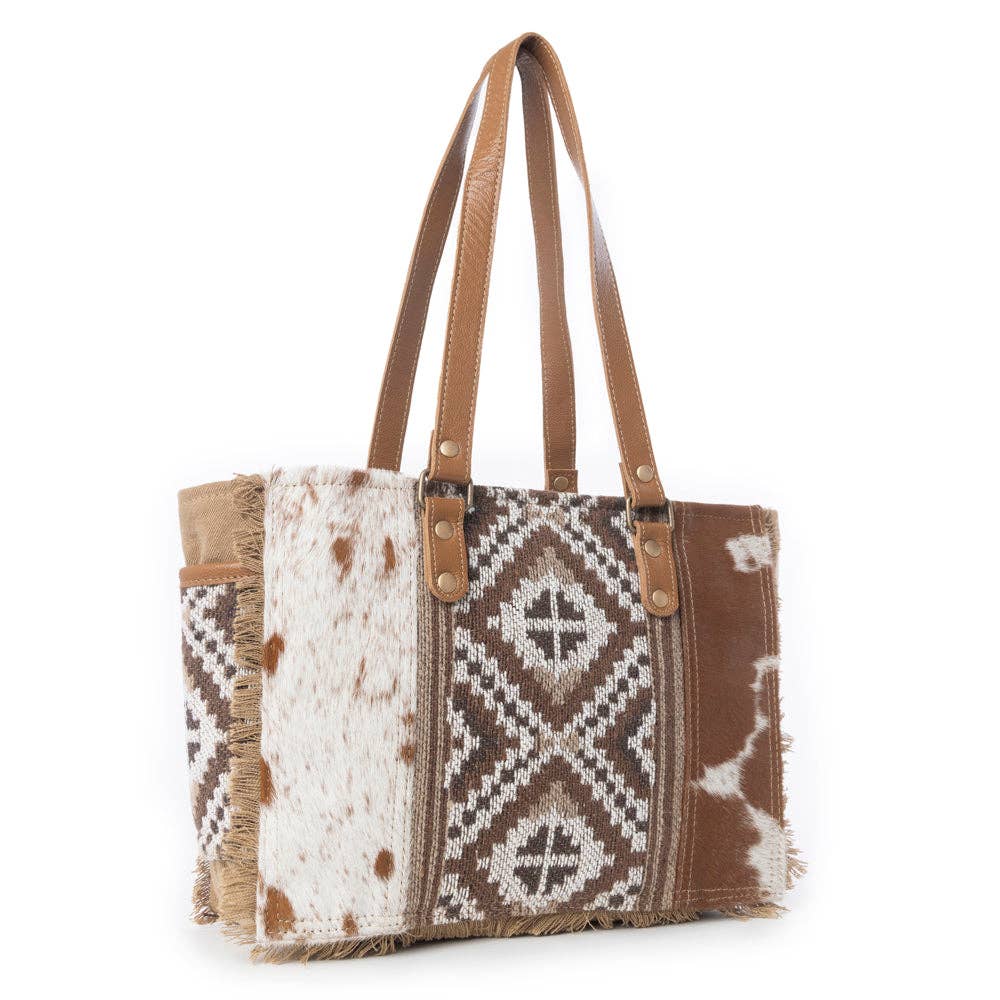 Stylish crossbody bag featuring a mix of patterned fabric and leather straps, perfect for a night out.