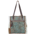 Amethyst Canvas & Hairon Pouch featuring a decorative pattern, zip closure, and handle for easy carrying of small essentials.