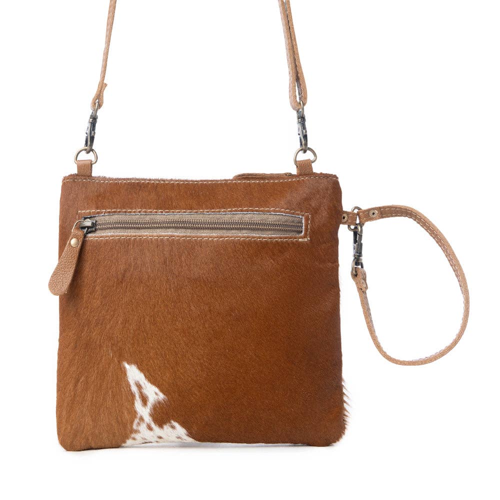 Brown leather handbag with hairon panel, adjustable strap, and back zipper for secure storage. Perfect for everyday use.