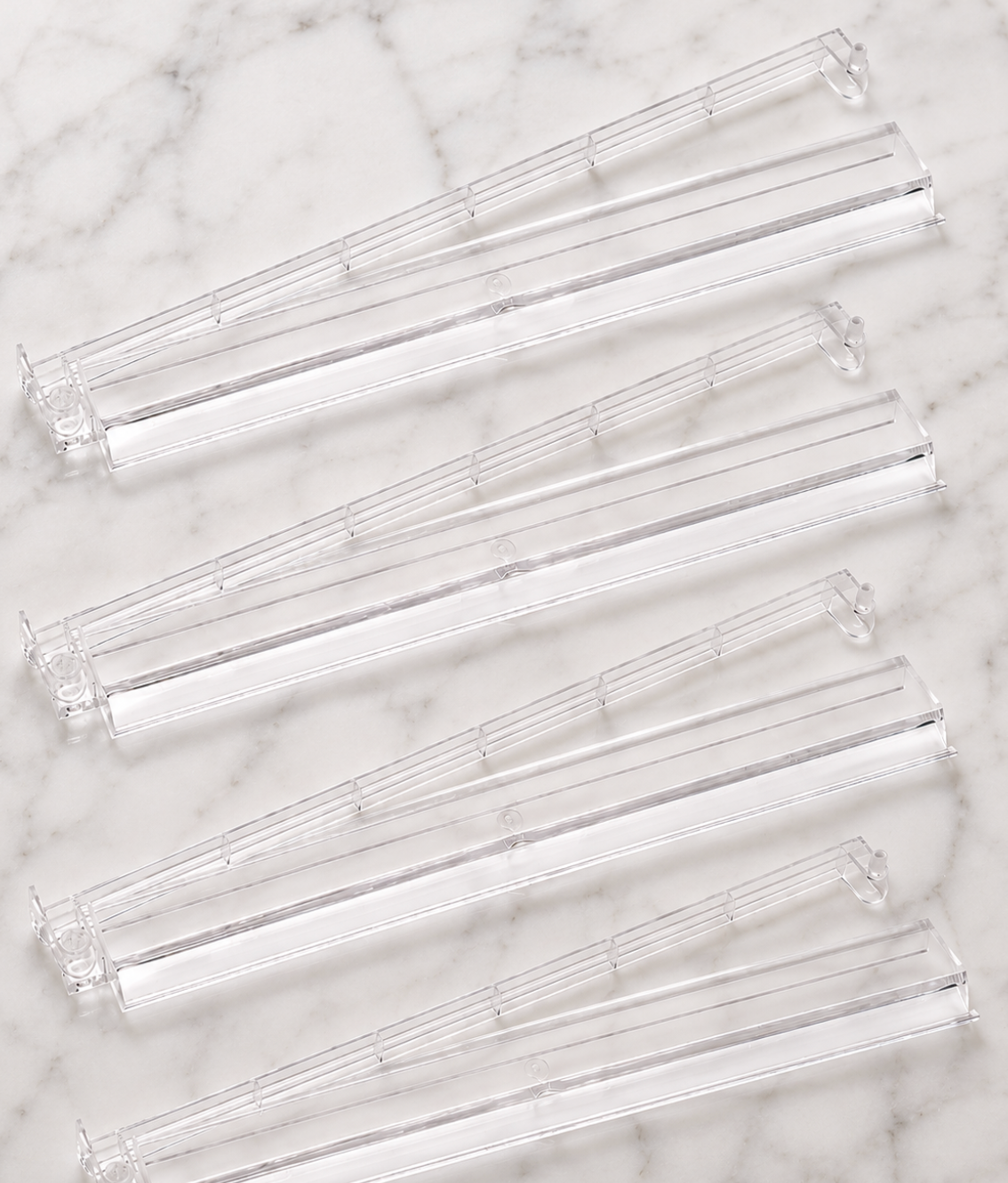 Clear Mahjong tile racks arranged in a row, designed for holding tiles during gameplay. Set of four for organized play.