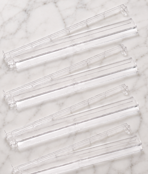Clear Mahjong tile racks arranged in a row, designed for holding tiles during gameplay. Set of four for organized play.