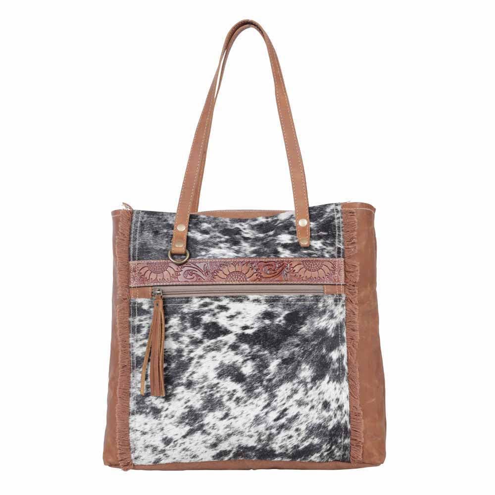 Neutral canvas and hairon bag with fringe detailing and adjustable leather strap, perfect for day or evening use.