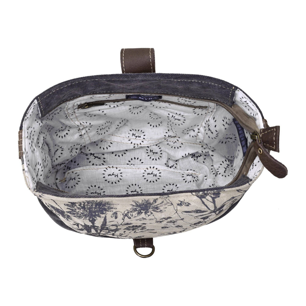 Shoulder bag featuring a patterned lining, zippered closure, and leather strap attachment, showcasing a stylish design.