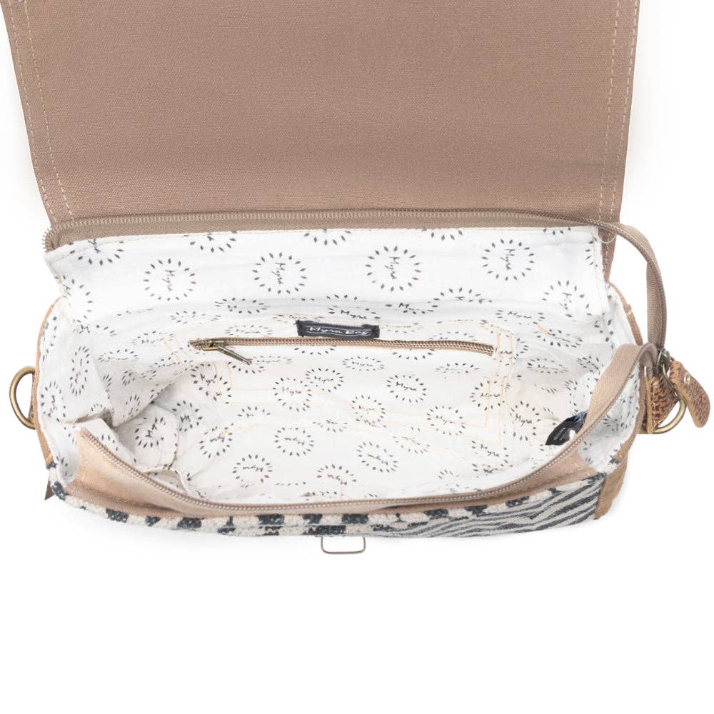 Messenger bag featuring a hairon flap, patterned interior lining, and a convenient zipper pocket. Perfect for everyday use.