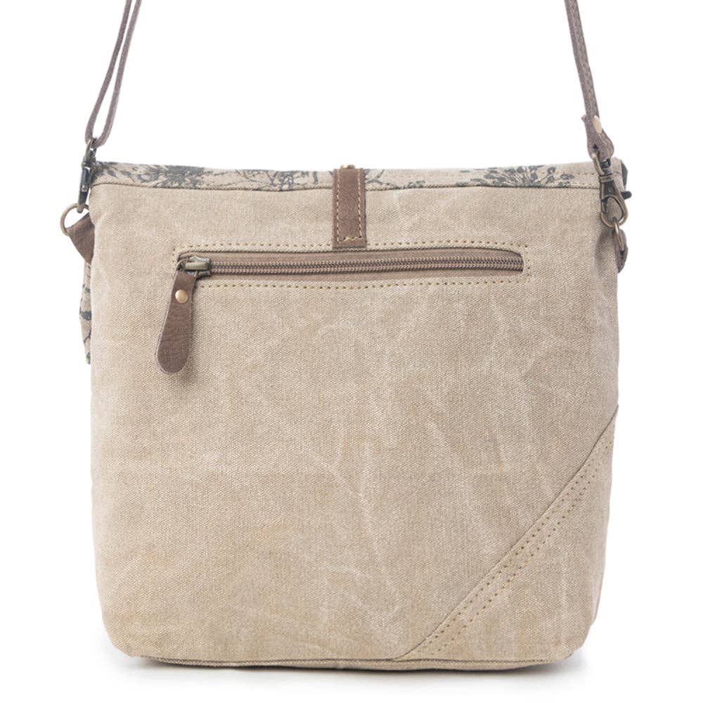Floral crossbody bag featuring a vibrant floral pattern on top and a rich chocolate leather bottom panel.