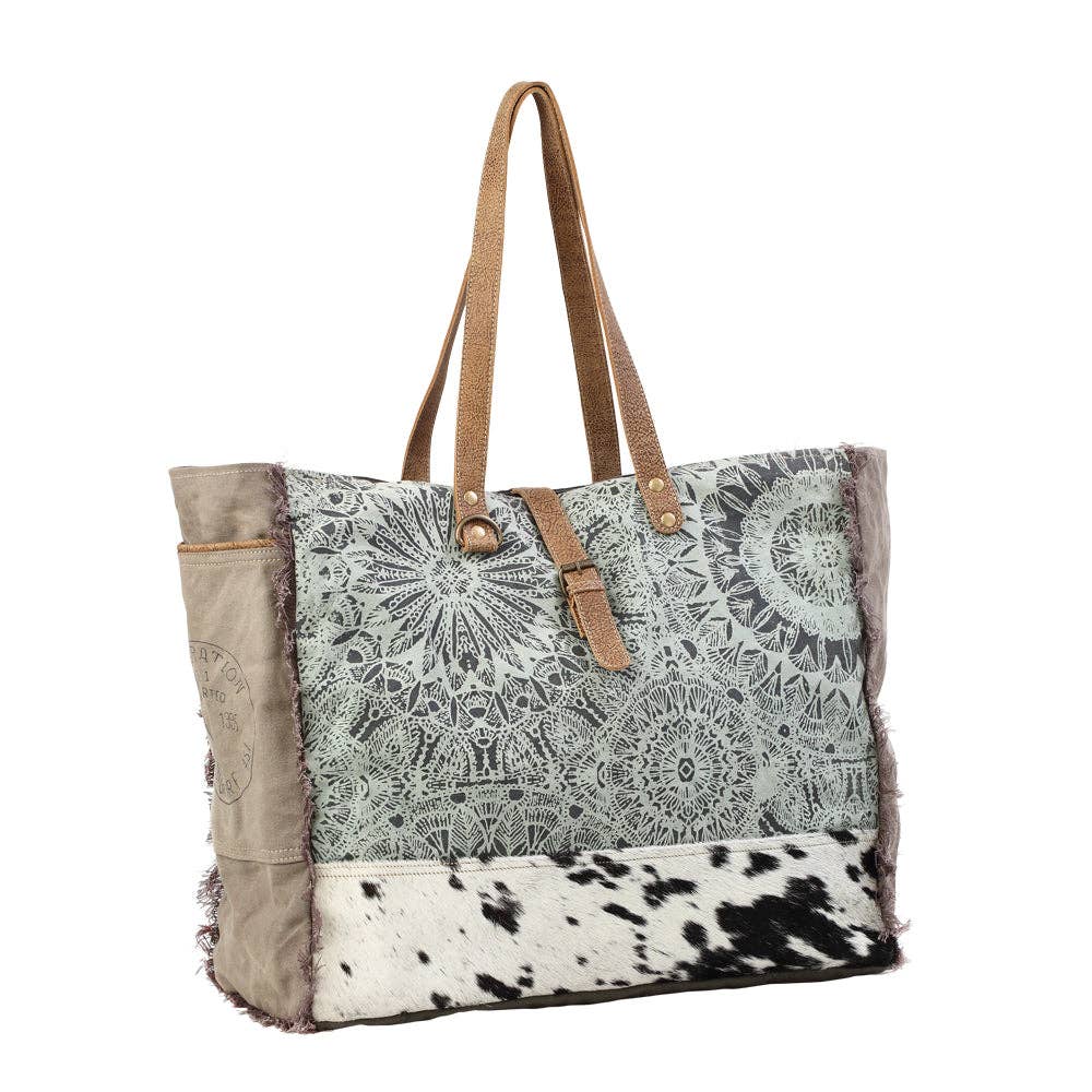 Floral print weekender bag featuring leather top handles and a spacious main compartment for stylish travel.