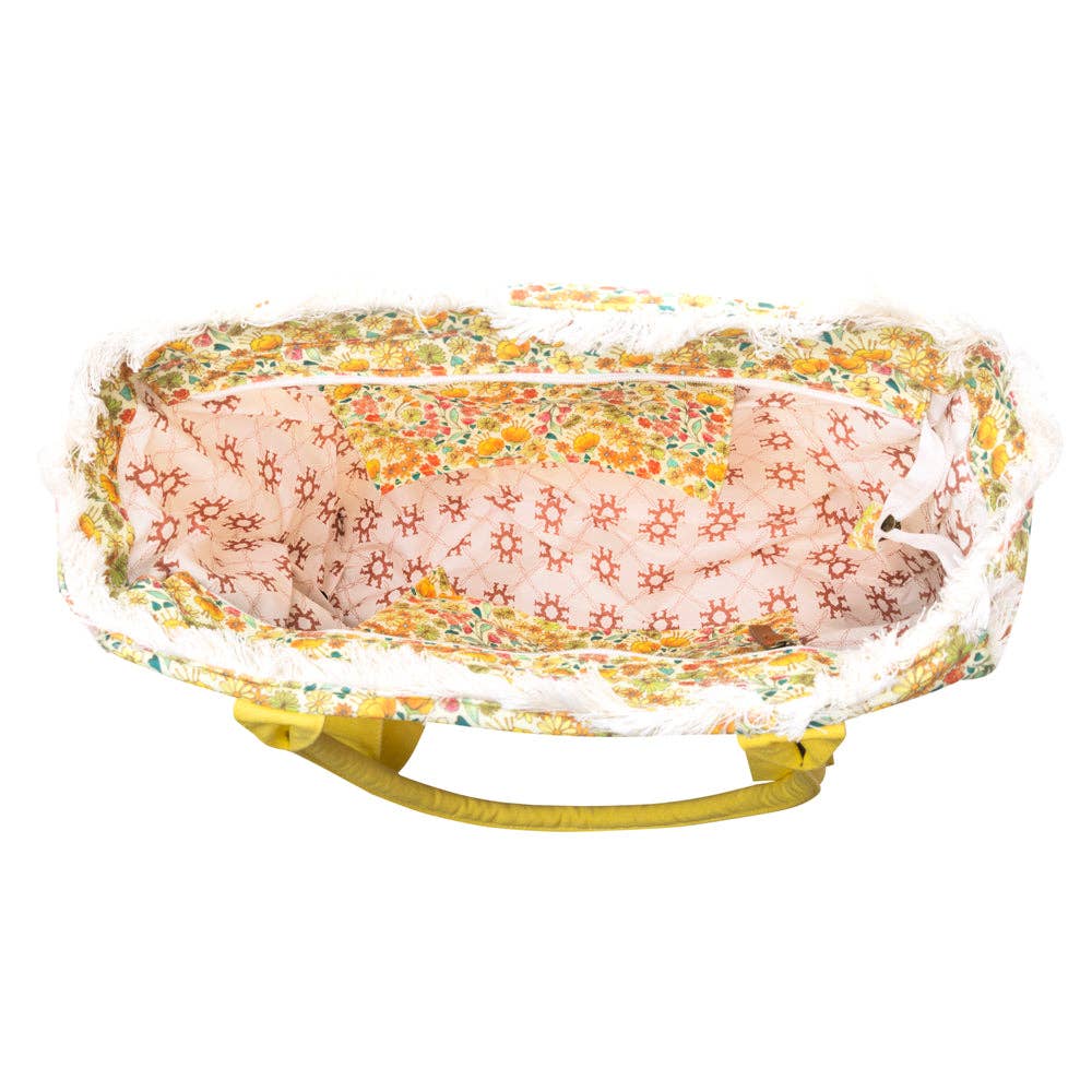 Wildflower print weekender bag with fringe detailing and desert blush carry straps, featuring a roomy zip-close main compartment.
