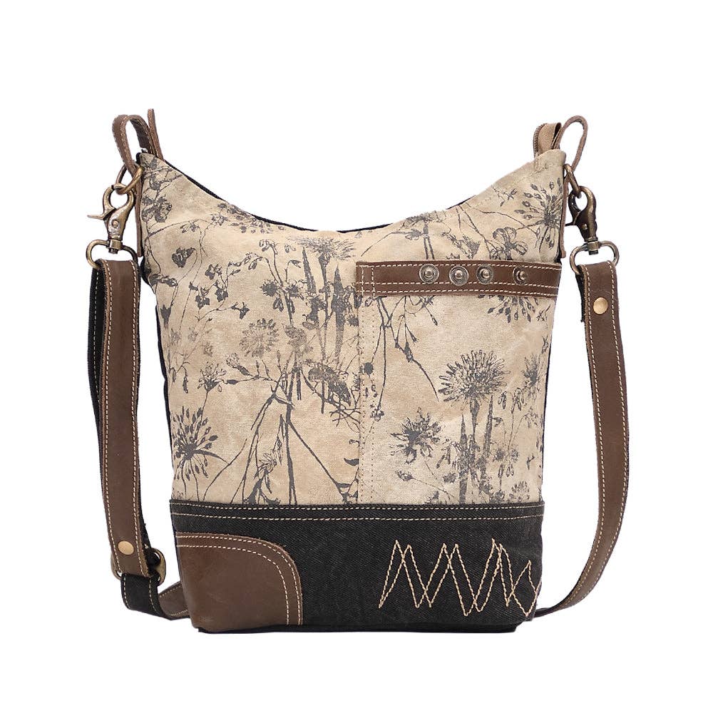 Floral canvas shoulder bag featuring a front pocket and zippered top closure, perfect for everyday style.