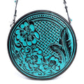 Round handbag featuring hand-tooled turquoise and ebony design with floral patterns and a zippered pocket on the back.