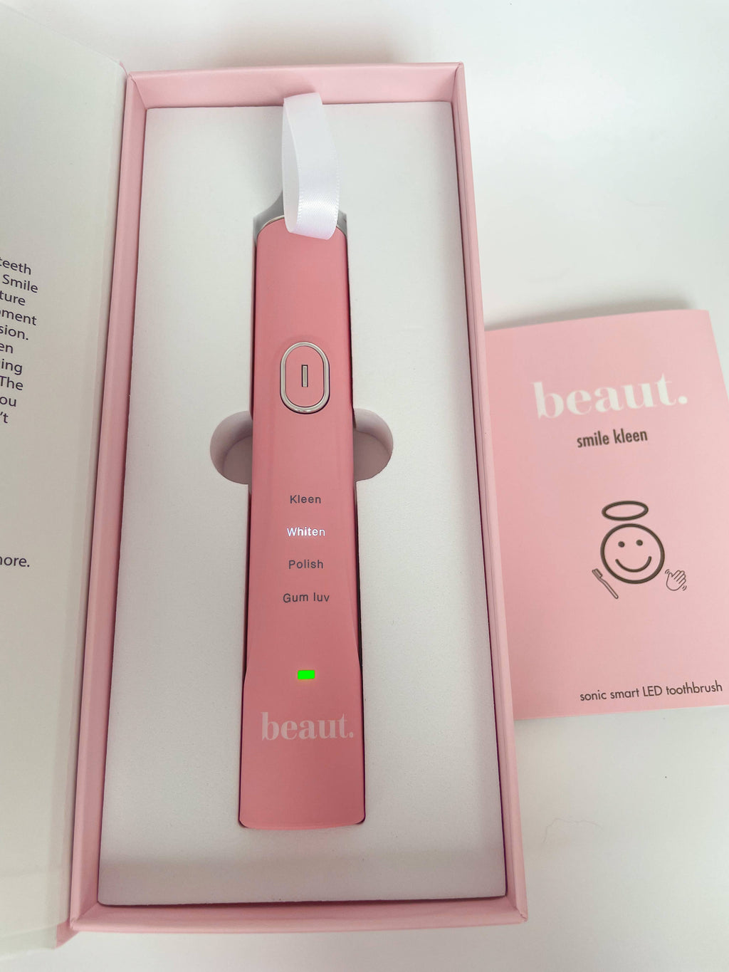 Pink and white Smile Kleen Sonic Vibration Toothbrush with power button and green light indicator, presented in a minimalistic pink box.