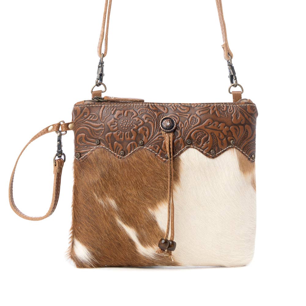 Ornate brown leather and hairon bag featuring a strong back zipper and adjustable straps for everyday style.