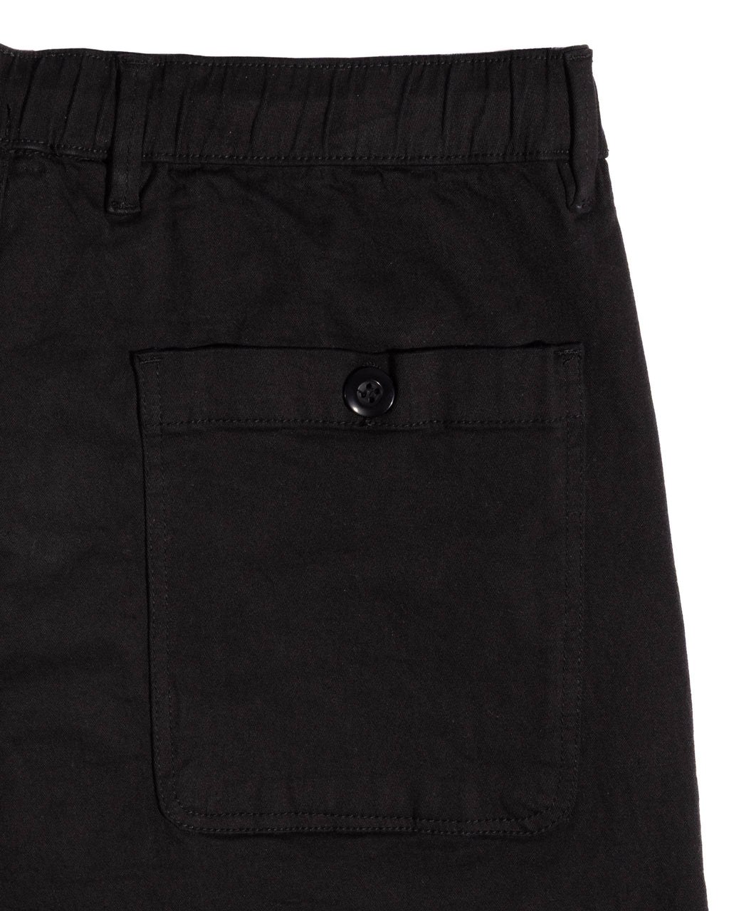 Elastic waistband with buttoned back pocket of relaxed fit cotton pants, showcasing durable stitching and solid color.